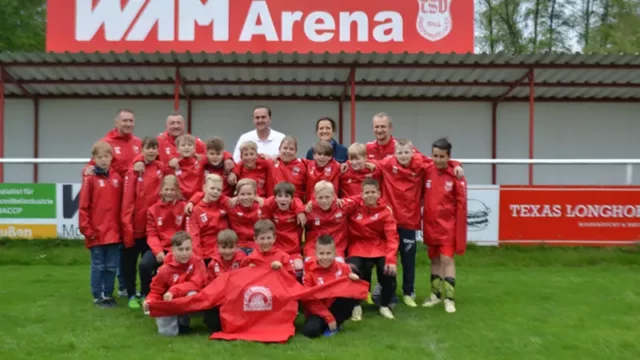 Die Jugendmannschaft des TSV Engelmannsreuth freut sich über neue, rote Regenjacken